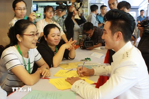 Ca sỹ Nguyễn Phi Hùng (phải) tham gia tư vấn để đăng ký hiến tạng trong một sự kiện Chung tay vì sự sống. (Ảnh: Phương Vy/TTXVN)