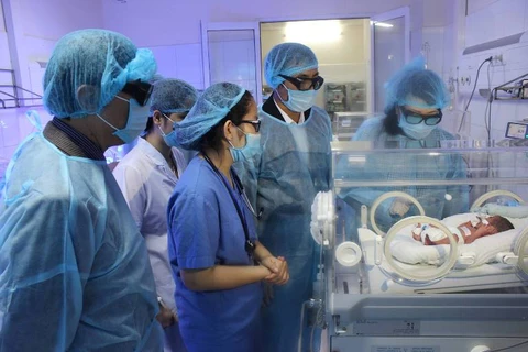 Bộ trưởng Bộ Y tế thăm trẻ sơ sinh tại Bệnh viện Sản nhi tỉnh Bắc Ninh. (Ảnh: PV/Vietnam+)
