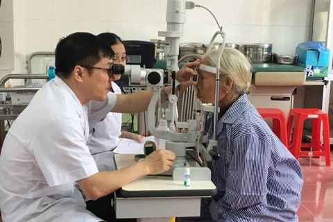 Bác sỹ khám mắt cho người cao tuổi. (Ảnh: PV/Vietnam+)