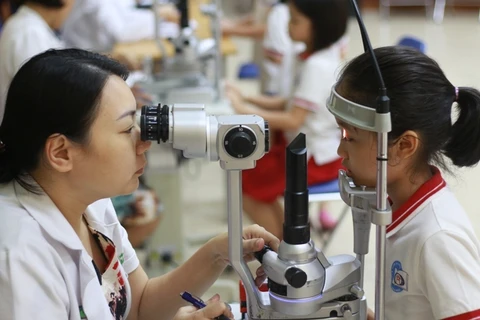 Bác sỹ Bệnh viện Mắt Hà Nội 2 khám mắt cho bệnh nhân nhi. (Ảnh: PV/Vietnam+)