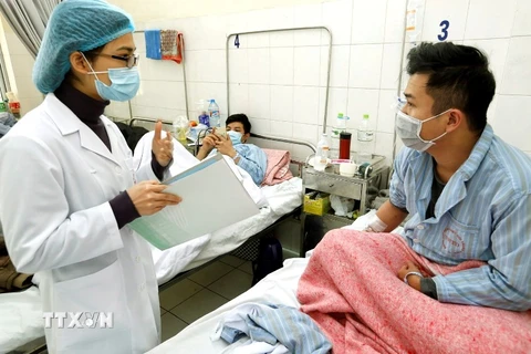  Cán bộ y tế tư vấn chăm sóc cho bệnh nhân mắc bệnh cúm tại bệnh viện Bệnh Nhiệt đới Trung ương. (Ảnh: Dương Ngọc/TTXVN)