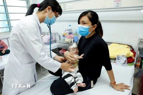 Bác sỹ chăm sóc và điều trị cho trẻ tại Bệnh viện Nhi Trung ương. (Ảnh: Dương Ngọc/TTXVN)