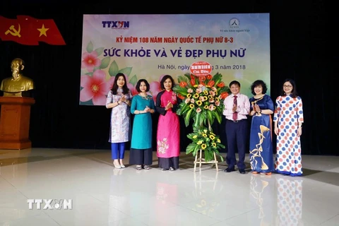 Phó Tổng giám đốc Thông tấn xã Việt Nam Đinh Đăng Quang tặng hoa chúc mừng Ban Nữ công cơ quan TTXVN. (Ảnh: Quang Quyết/TTXVN)