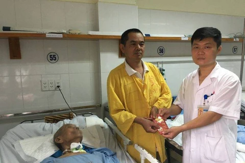 Đại diện Khoa Phẫu thuật Thần kinh II Bệnh viện HN Việt Đức trao phần quà của các nhà hảo tâm đến gia đình bệnh nhân. (Ảnh: Bác sỹ cung cấp)