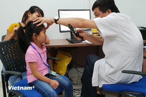 Bác sỹ Bệnh viện Mắt Hà Nội 2 khám mắt cho trẻ em ở Tuyên Quang. (Ảnh: T.G/Vietnam+)