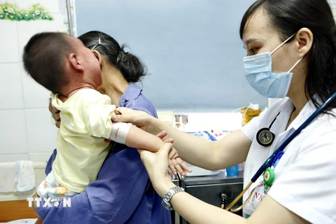 Bác sỹ Bệnh viện bệnh Nhiệt đới Trung ương điều trị trẻ mắc sởi bị viêm phổi rất nặng do không tiêm chủng. (Ảnh: TXVN)