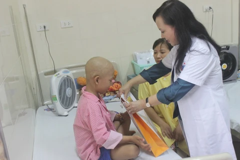 Bộ trưởng Bộ Y tế Nguyễn Thị Kim Tiến trao quà cho bệnh nhân ung thư. (Ảnh: PV/Vietnam+)