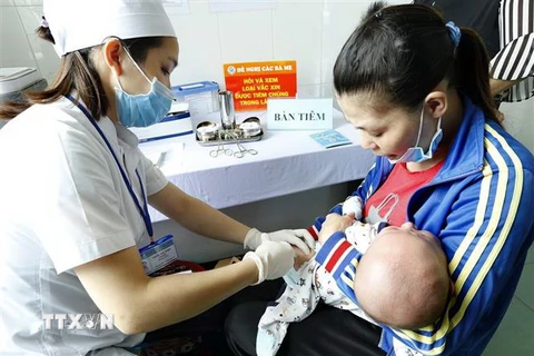 Nhân viên y tế tiêm chủng cho trẻ. (Ảnh:TTXVN/Vietnam+)