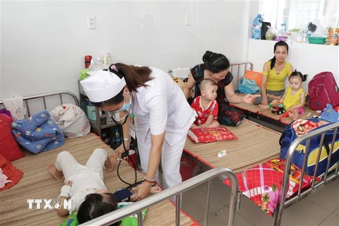 Bác sỹ thăm khám cho bệnh nhân mắc tay chân miệng tại tỉnh Bến Tre. (Ảnh: TTXVN/Vietnam+)
