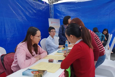 Người dân viết vào phiếu đăng ký tham gia hiến tạng. (Ảnh: PV/Vietnam+) 