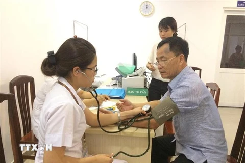 Đo huyết áp kiểm tra sức khoẻ cho người bệnh. (Ảnh: TTXVN/Vietnam+)