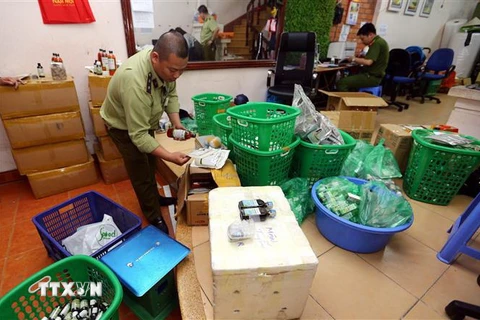 Đội quản lý thị trường số 15 kiểm tra và thu giữ lượng lớn hàng thực phẩm chức năng không rõ nguồn gốc tại số nhà 5, ngõ 125 thuộc quận Hoàng Mai (Hà Nội). (Ảnh: Danh lam/TTXVN)