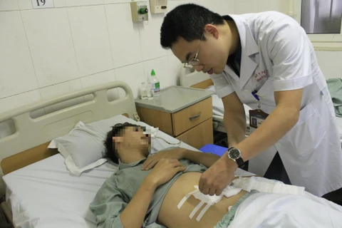 Bác sỹ Bệnh viện E khám lại cho bệnh nhân sau phẫu thuật. (Ảnh: PV/Vietnam+)