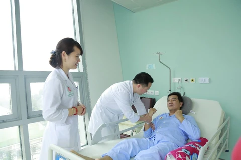 Các bác sỹ Bệnh viện Trung ương Quân đội 108 thăm khám cho bệnh nhân. (Ảnh: PV/Vietnam+)