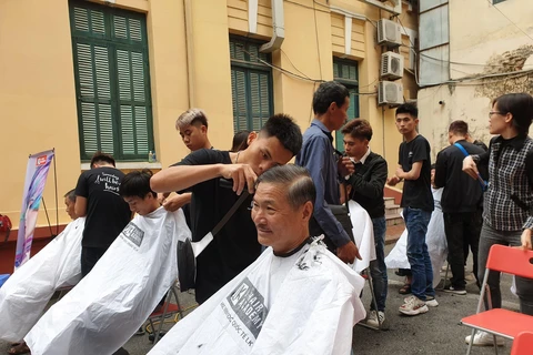 Cắt tóc cho bệnh nhân tại Ngày hội nhân ái - Kết nối sẻ chia. (Ảnh: PV/Vietnam+)