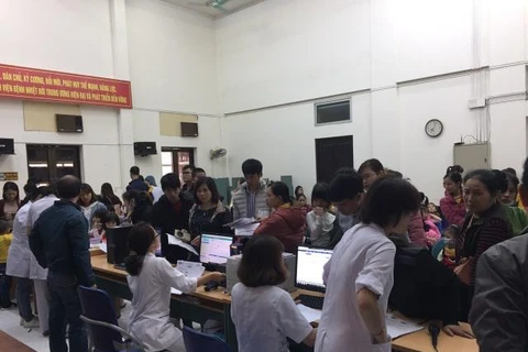 Phụ huynh đưa trẻ đi xét nghiệm tại Bệnh viện Bệnh Nhiệt đới Trung ương. (Ảnh: PV/Vietnam+)