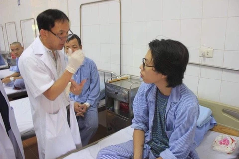 Bác sỹ Nguyễn Thanh Thái kiểm tra sức khoẻ của bệnh nhân sau phẫu thuật. (Ảnh: PV/Vietnam+)