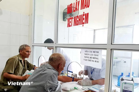 Người dân khám bệnh, lấy máu xét nghiệm tại một cơ sở y tế. (Ảnh: PV/Vietnam+)