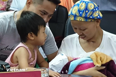 Gia đình chị Liên đón em bé xuất viện về nhà. (Ảnh: PV/Vietnam+)