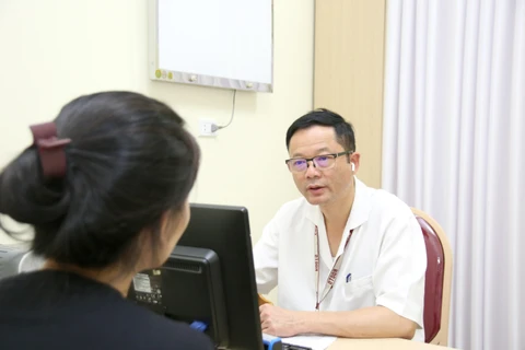 Phó giáo sư Đỗ Trường Thành khám cho bệnh nhân về sỏi tiết niệu. (Ảnh: PV/Vietnam+)