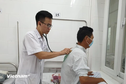 Bác sỹ Bệnh viện Bạch Mai khám cho bệnh nhân mắc sốt xuất huyết. (Ảnh: T.G/Vietnam+)