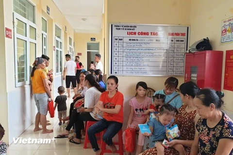 Người dân và trẻ nhỏ chờ tiêm chủng cho trẻ tại Trung tâm y tế xã Đoàn Kết, huyện Vân Đồn. (Ảnh: T.G/Vietnam+)