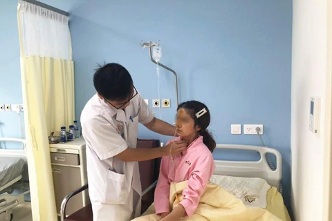 Bác sỹ Hưng khám cho bệnh nhân. (Ảnh: PV/Vietnam+)