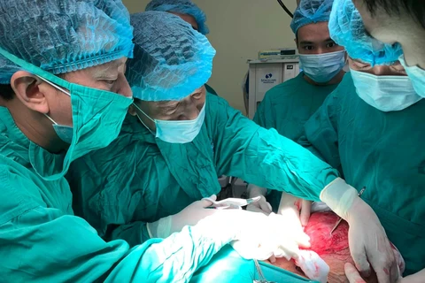 Các bác sỹ thực hiện phẫu thuật khối u cho bệnh nhân. (Ảnh: PV/Vietnam+)