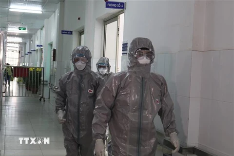 Các bác sỹ Bệnh viện Chợ rẫy Thành phố Hồ Chí Minh mặc đồ bảo hộ trước khi vào khu vực cách ly. (Ảnh: Đinh Hằng/TTXVN)