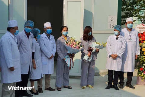 Tặng hoa cho các bệnh nhân khỏi bệnh. (Ảnh: PV/Vietnam+)