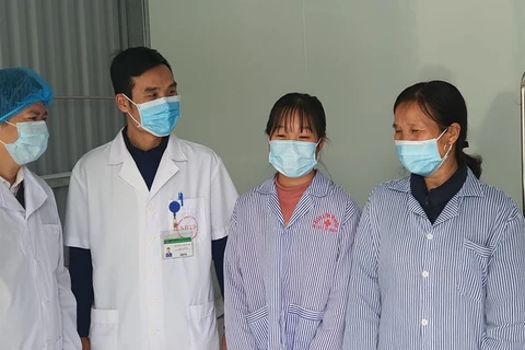 Các bác sỹ chúc mừng hai bệnh nhân đã khỏi COVID-19. (Ảnh: PV/Vietnam+)
