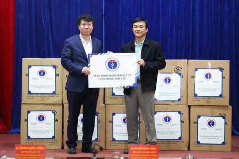 Thứ trưởng Bộ Y tế Trương Quốc Cường tặng khẩu trang y tế cho các đơn vị. (Ảnh: PV/Vietnam+)