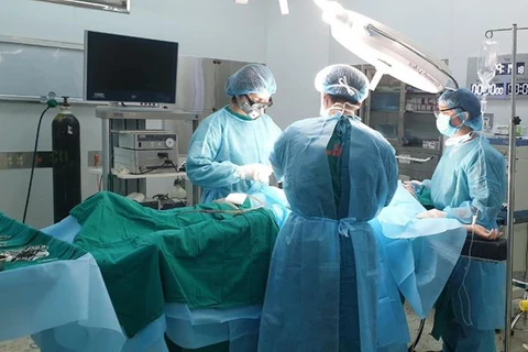 Các bác sỹ thực hiện ca phẫu thuật cho bệnh nhân. (Ảnh: PV/Vietnam+)