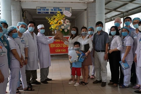 Người nhà bệnh nhân 6 tuổi tặng hoa cảm ơn các bác sỹ. (Ảnh: Vietnam+)