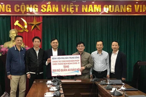 Giám đốc Bệnh viện Phụ sản Trung ương trao 500 bộ quần áo bảo hộ chống dịch COVID-19 cho Hội Hữu nghị và Hợp tác Việt Nam- Pháp. (Ảnh: PV/Vietnam+)