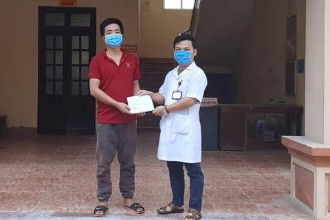 Bệnh nhân được các bác sỹ của Bệnh viện Đa khoa huyện Kim Sơn công bố khỏi bệnh. (Ảnh: PV/Vietnam+)