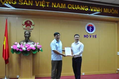 Thứ trưởng Bộ Y tế Đỗ Xuân Tuyên trao Quyết định bổ nhiệm cho ông Lê Thanh Dũng. (Ảnh: PV/Vietnam+)