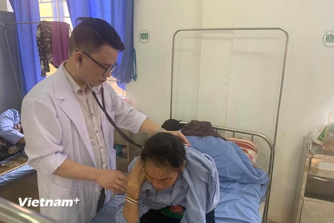 Bác sỹ Trần Hữu Cảnh khám cho một bệnh nhân tại Bệnh viện đa khoa huyện Quỳnh Nhai. (Ảnh: PV/Vietnam+)