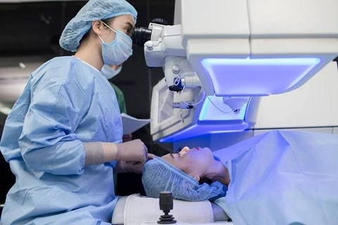 Bác sỹ tiến hành phẫu thuật tật khúc xạ cho một bệnh nhân. (Ảnh: PV/Vietnam+)