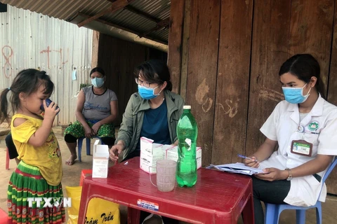 Nhân viên y tế hướng dẫn trẻ em tại xã Quảng Hòa, Đắk Nông uống thuốc phòng bệnh bạch hầu. (Ảnh: TTXVN phát)