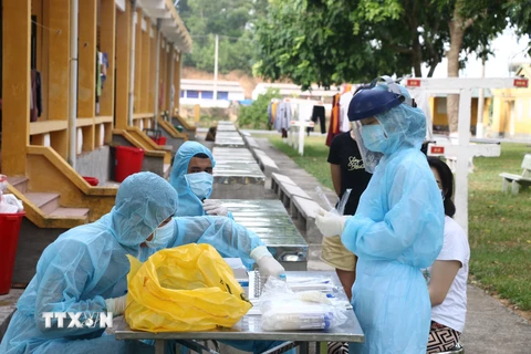 Nhân viên y tế lấy mẫu xét nghiệm SARS-CoV-2 cho 185 công dân trong khu vực cách ly. (Ảnh: Hoa Mai/TTXVN)