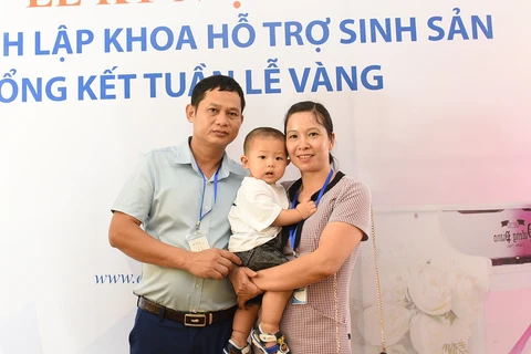 Vợ chồng chị Nguyễn Thị Minh và con trai 9 tháng tuổi. (Ảnh: PV/Vietnam+)