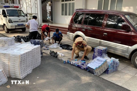 Lực lượng chức năng tỉnh Bình Dương tạm giữ các đối tượng có hành vi buôn lậu thuốc lá ngoại. (Ảnh: Nguyễn Văn Việt - TTXVN)