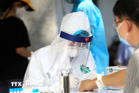Nhân viên Y tế lấy mẫu máu test nhanh cho các công dân trở về từ Đà Nẵng. (Ảnh: Thành Đạt/TTXVN)