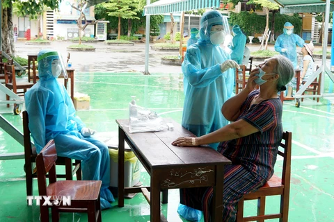Lấy mẫu sinh phẩm của người dân vùng phong tỏa tại Đà Nẵng để xét nghiệm SARS-CoV-2. (Ảnh: TTXVN phát)