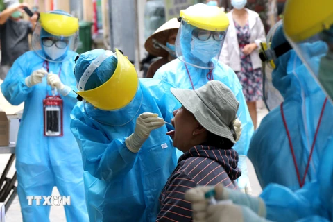 Nhân viên y tế lấy mẫu xét nghiệm cho người lớn tuổi, sức đề kháng kém có nguy cơ lây nhiễm cao tại Đà Nẵng. (Ảnh: Quốc Dũng/TTXVN)