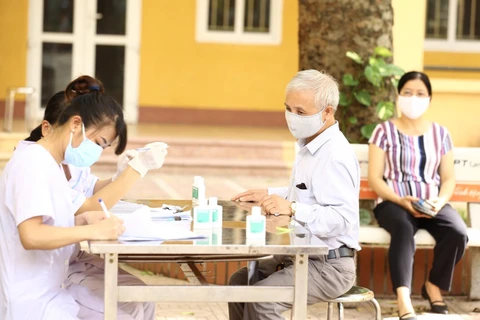 Người về từ Đà Nẵng đến đăng ký lấy mẫu dịch hầu họng để xét nghiệm bằng phương pháp RT-PCR tại Hà Nội . (Ảnh: Minh Quyết/TTXVN)