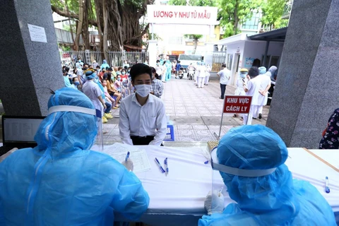 Người dân trở về từ Đà Nẵng đến khai báo lấy mẫu xét nghiệm bằng phương pháp RT-PCR tại Trung Tâm Y Tế quận Hai Bà Trưng. (Ảnh: Minh Quyết/TTXVN)