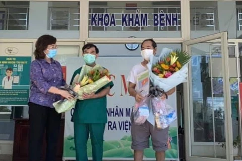 BN936 và đại diện Trung tâm Y tế Hòa Vang nhận hoa nhân sự kiện bệnh nhân COVID-19 cuối cùng được điều trị khỏi tại Đà Nẵng. (Ảnh: PV/Vietnam+)