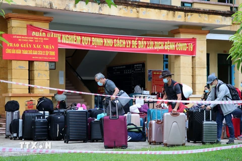 Công dân hoàn thành thời gian cách ly vận chuyển đồ đặc cá nhân để trở về địa phương. (Ảnh: Thanh Hải/TTXVN)